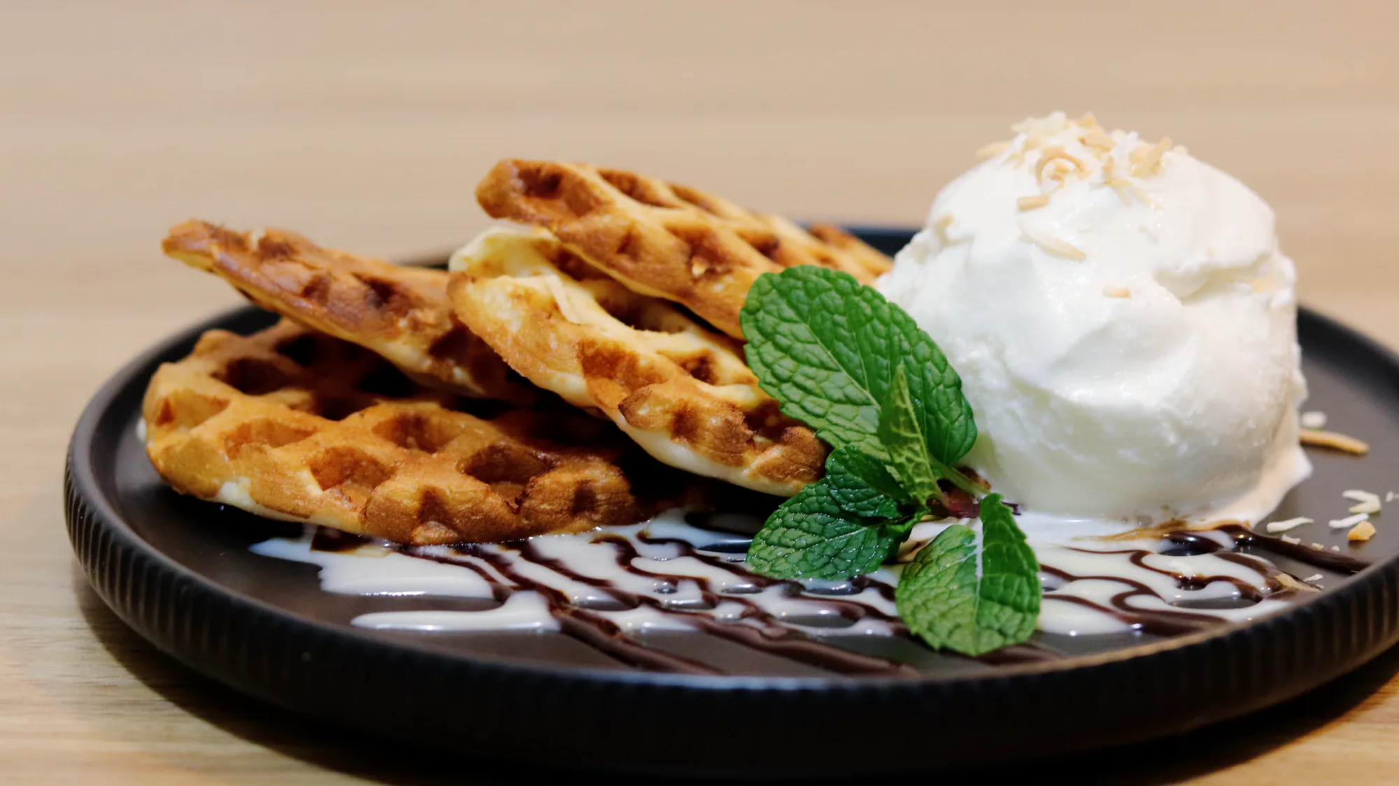 Coconut waffles with coconut ice cream, mint and toasted coconut.
