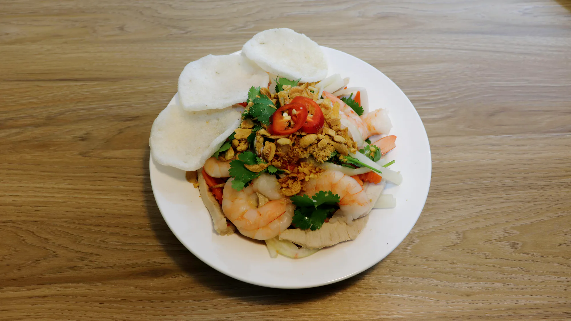 A lotus stem salad topped with prawns, peanuts, herbs, chilli and prawn crackers.